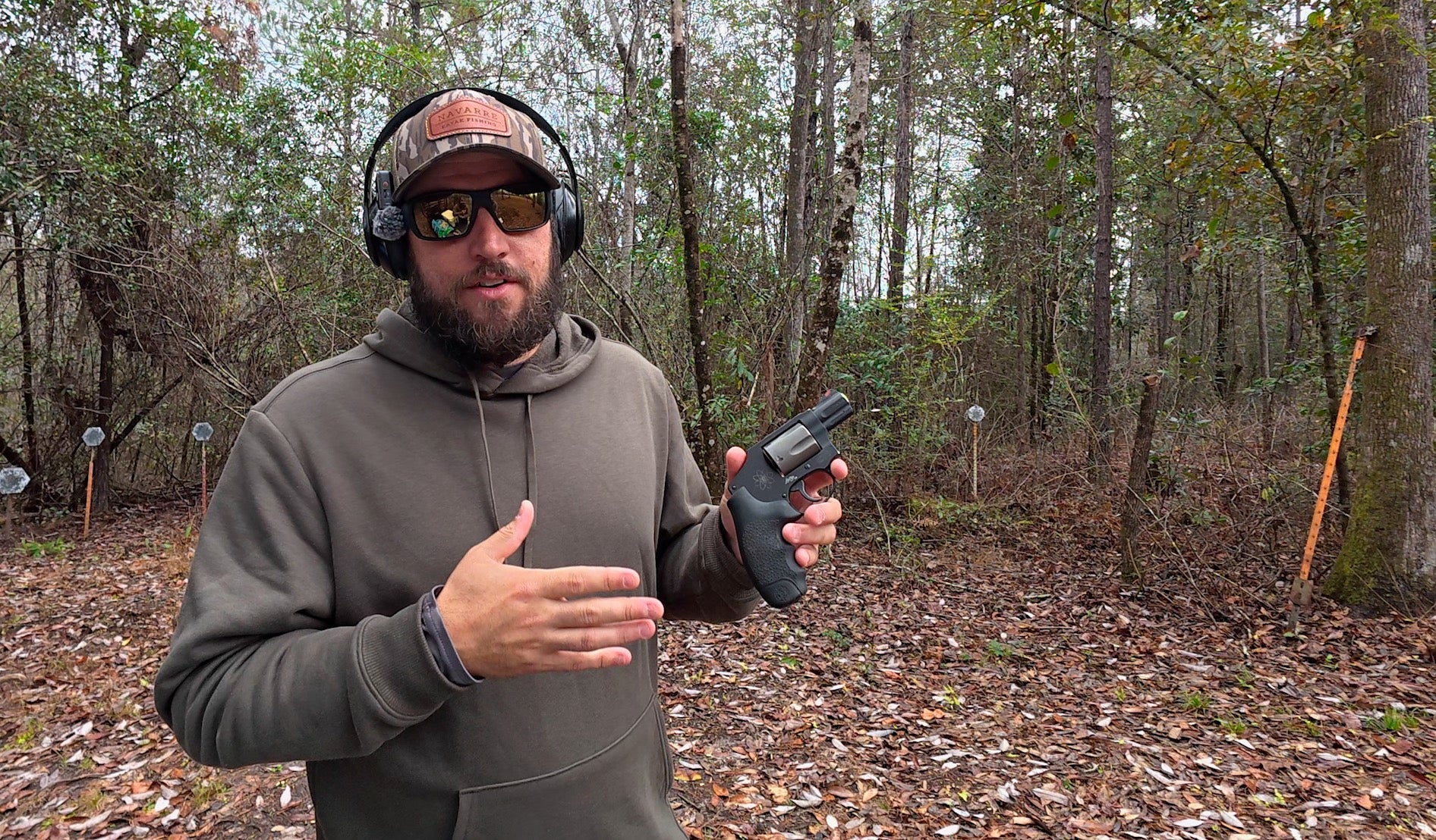 Man holding a handgun in a wooded area